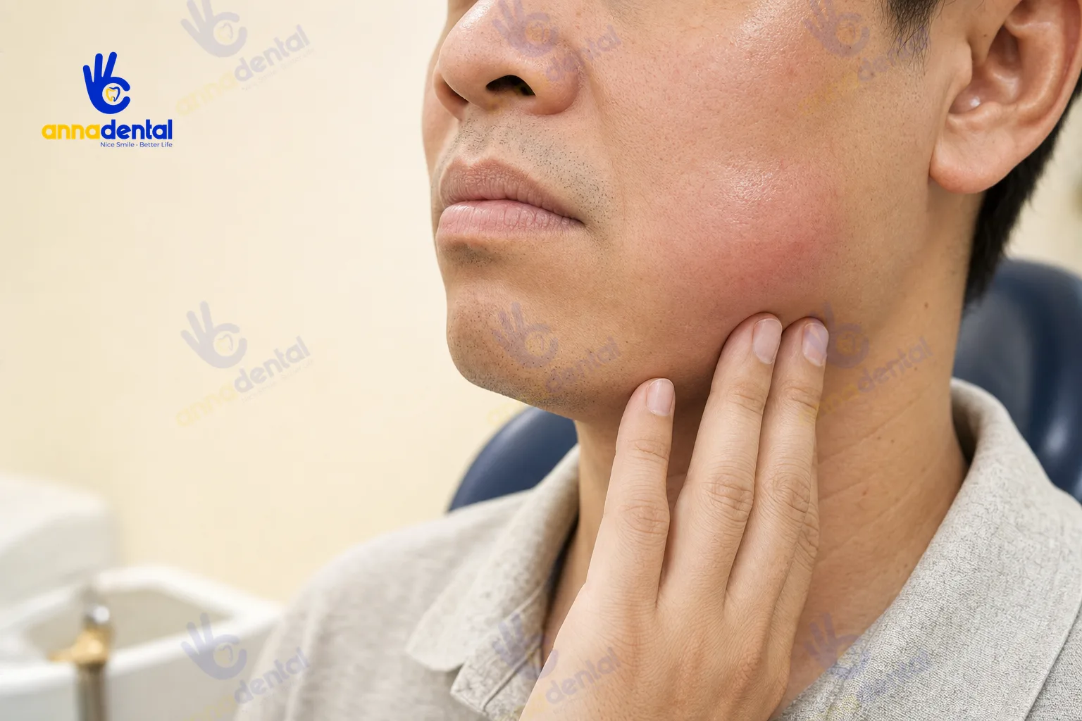Bệnh nhân chạm tay vào vùng má sưng do răng nhiễm trùng