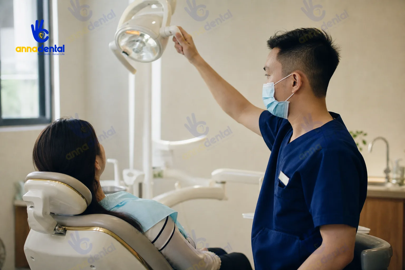 Bác sĩ chỉnh đèn cho bệnh nhân trong phòng khám nha khoa hiện đại
