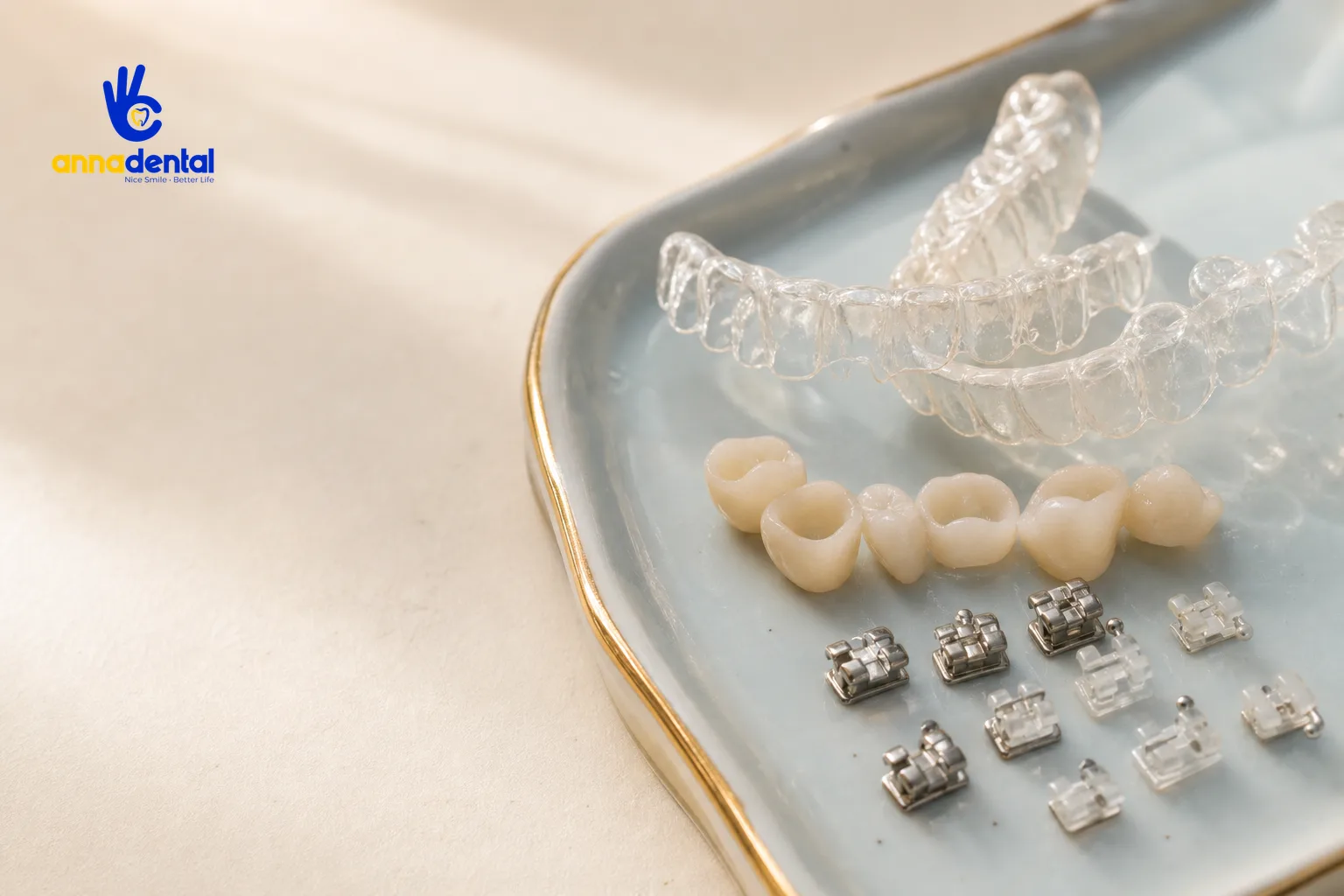 Bộ mắc cài niềng răng, khay niềng và mão sứ đặt trên khay màu ivory